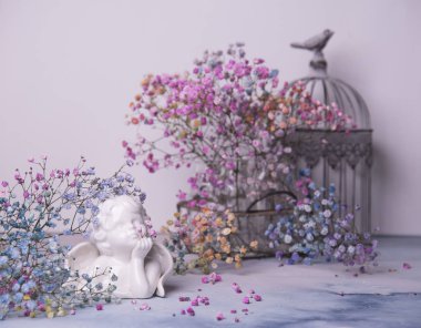 melek figürü ve ışık arka plan üzerinde kuru çiçekler