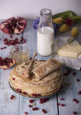 Krep nar taneleri, süt ve tereyağı ile tabakta bal ile haddelenmiş