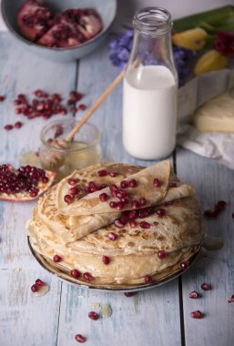 Krep nar taneleri, süt ve tereyağı ile tabakta bal ile haddelenmiş