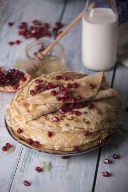 Krep nar taneleri, süt ve tereyağı ile tabakta bal ile haddelenmiş