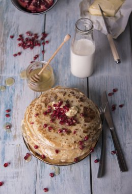 süt ve tereyağı ile tabakta bal ile nar taneleri, krep, kapat