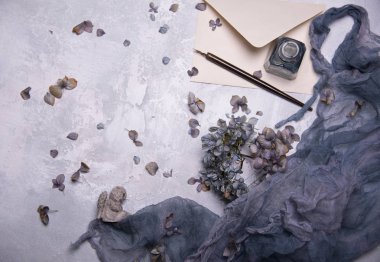 Kuru çiçek yaprakları, kağıt sayfalarının, yazma mürekkep ve gri arka plan üzerinde vintage kalem kompozisyon