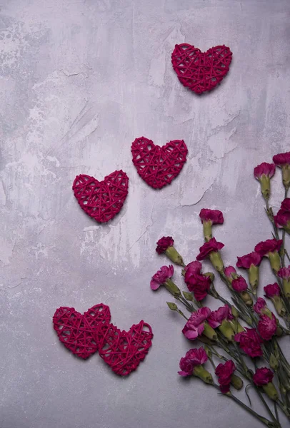 枝編み細工品赤い心と灰色の背景にクローブ ピンクの花バレンタインの日カード テンプレート — ストック写真