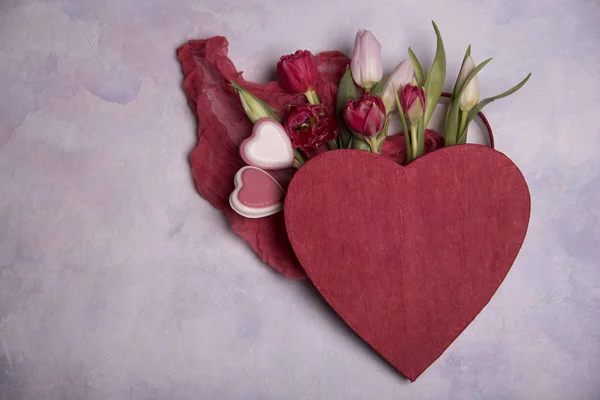 close up of tulips and hearts on light background