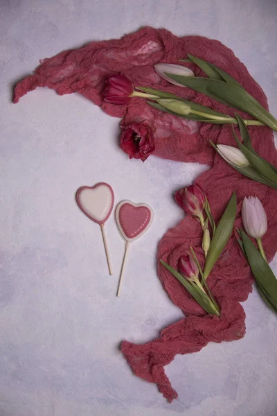 close up of tulips and hearts on light background