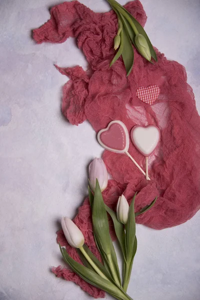 close up of tulips and hearts on light background