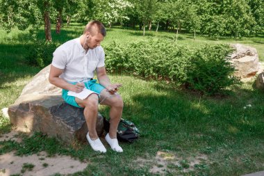 Yetenekli bir genç adam yazar doğa, freelancing, temiz hava. Ücretsiz çalışma takvimi kavramı.