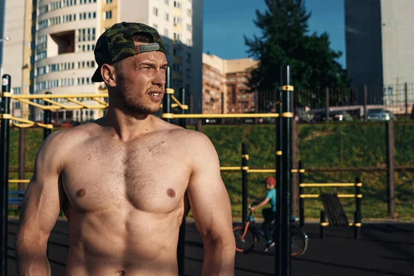 Eğitim, bir atlet, şehirde eğitim açık sonra dinlenme çıplak bir gövde ile genç bir kas adam