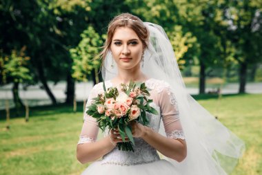 Güzel bir kız, bir beyaz gelinlik yeşil doğanın bir arka plan üzerine gelin. Düğün, Aile oluşturma.