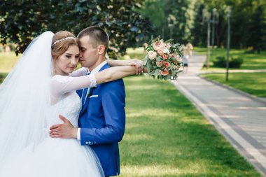 Doğa çerçevede bir klasik mavi elbiseli güzel adam ve kız, beyaz bir gelinlik, gelin damat. Düğün, Aile oluşturma.