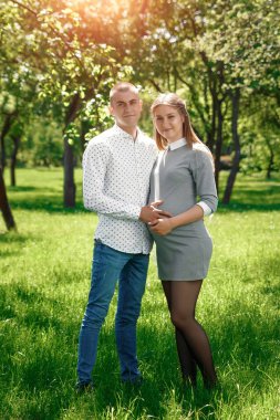 Mutlu hamile, evli çiftimiz parkta. Bir mucize, bir çocuk beklentisiyle. Aile hayatı çocuk gebelik aile babası, annesi.