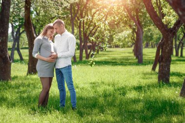 Mutlu hamile, evli çiftimiz parkta. Bir mucize, bir çocuk beklentisiyle. Aile hayatı çocuk gebelik aile babası, annesi.