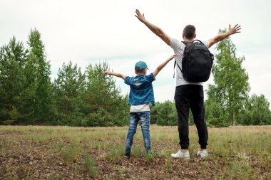 Bir sırt çantası, bir baba ve oğlu sırasında yürüyüş bir yürüyüş üzerinde olan bir adam ormanda yürür. Aile hayatı, Aile, çocuk yetiştirme ile eğlence.