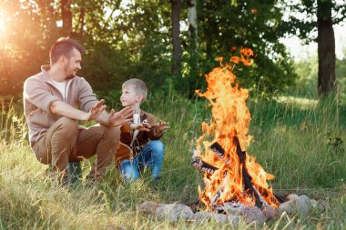 Baba ve oğul ellerine yeşil doğanın bir arka plan karşı ateşli sıcak. Yürüyüş, zaman aile, Aile hayatı, açık rekreasyon.