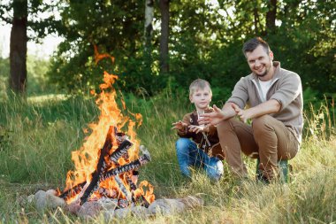 Baba ve oğul ellerine yeşil doğanın bir arka plan karşı ateşli sıcak. Yürüyüş, zaman aile, Aile hayatı, açık rekreasyon.