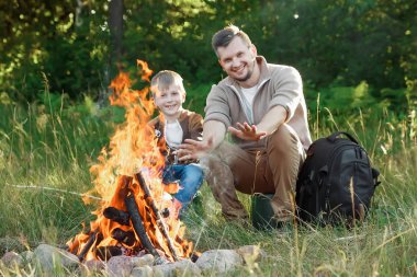 Baba ve oğul ellerine yeşil doğanın bir arka plan karşı ateşli sıcak. Yürüyüş, zaman aile, Aile hayatı, açık rekreasyon.