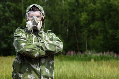 Bir adam bir maske ve gözlük ve bir kamuflaj doğa arka planı uygun. Kimyasal orduları.
