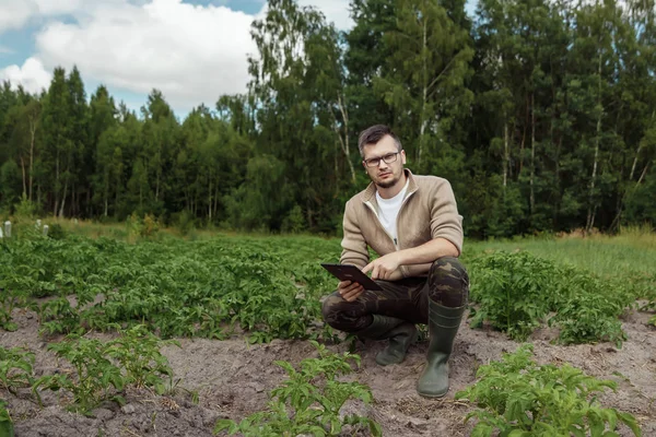 Rolnikiem Mężczyzna Siedzi Polu Tablecie Nowoczesne Zastosowania Technologii Działalności Rolniczej — Zdjęcie stockowe