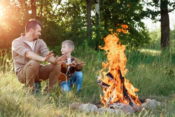 Baba ve oğul ellerine yeşil doğanın bir arka plan karşı ateşli sıcak. Yürüyüş, zaman aile, Aile hayatı, açık rekreasyon.