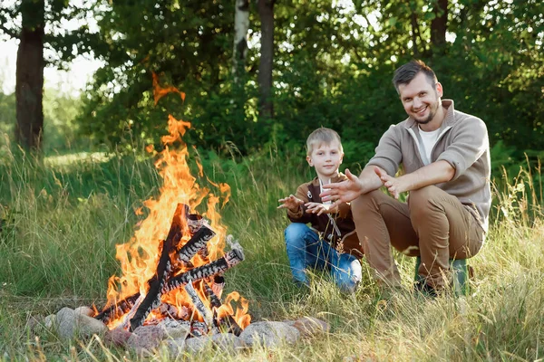 Baba ve oğul ellerine yeşil doğanın bir arka plan karşı ateşli sıcak. Yürüyüş, zaman aile, Aile hayatı, açık rekreasyon.