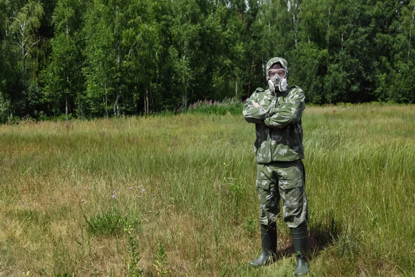 Bir adam bir maske ve gözlük ve bir kamuflaj doğa arka planı uygun. Kimyasal orduları.
