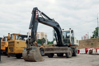 Ekskavatör inşaat sahasında kum, taş, mavi gökyüzü arka planı ezilmiş. İnşaat malzemeleri, inşaat.
