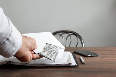 Bir adamın elini bir zarf ve bize dolar. Rüşvet, yolsuzluk iş kavramı olarak beyaz bir zarf sunan bir girişimci.