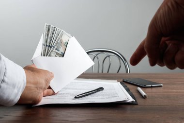 Bir adamın elini bir zarf ve bize dolar. Rüşvet, yolsuzluk iş kavramı olarak beyaz bir zarf sunan bir girişimci.