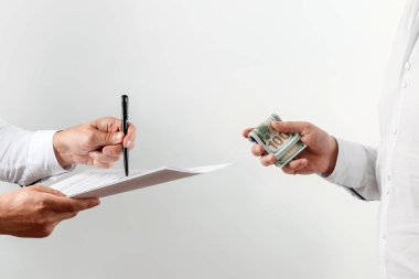 Eller, para, rüşvet, beyaz bir arka plan üzerinde izole bir sözleşme imzalamak sunmaktadır. Yüz dolarlık banknotlar. Yolsuzluğa karşı rüşvet iş faaliyetlerine karşı kavramı.