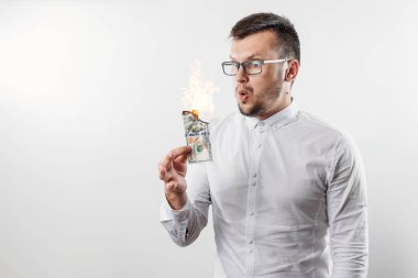 Bir adam bizi dolar yanan elinde, yanan para tutar. Enflasyon, Döviz ve yetki devri satın bir düşüş kavramı.