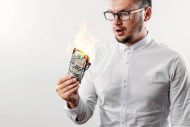 Bir adam bizi dolar yanan elinde, yanan para tutar. Enflasyon, Döviz ve yetki devri satın bir düşüş kavramı.