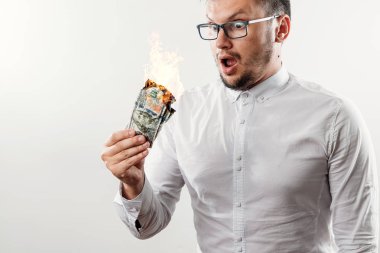 Bir adam bizi dolar yanan elinde, yanan para tutar. Enflasyon, Döviz ve yetki devri satın bir düşüş kavramı.