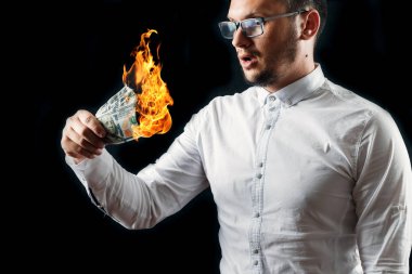 Bir adam bizi dolar yanan elinde, yanan para tutar. Enflasyon, Döviz ve yetki devri satın bir düşüş kavramı.