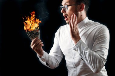 Bir adam bizi dolar yanan elinde, yanan para tutar. Enflasyon, Döviz ve yetki devri satın bir düşüş kavramı.