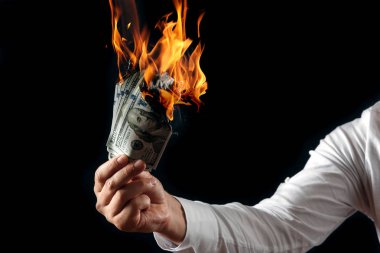 Erkek el yakın çekim, yanan para bize dolar yanan elinde tutar. Siyah arka plan, ayrı tut. Enflasyon, Döviz ve yetki devri satın bir düşüş kavramı.