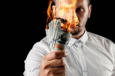 Bir adam bizi dolar yanan elinde, yanan para tutar. Enflasyon, Döviz ve yetki devri satın bir düşüş kavramı.