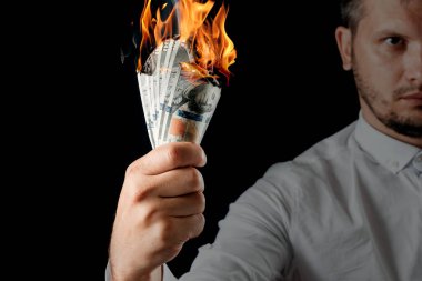 Bir adam bizi dolar yanan elinde, yanan para tutar. Enflasyon, Döviz ve yetki devri satın bir düşüş kavramı.