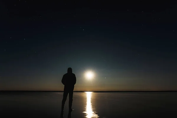 Hombre Encuentra Puesta Sol Luna Bajo Cielo Estrellado Con Estrellas —  Fotos de Stock