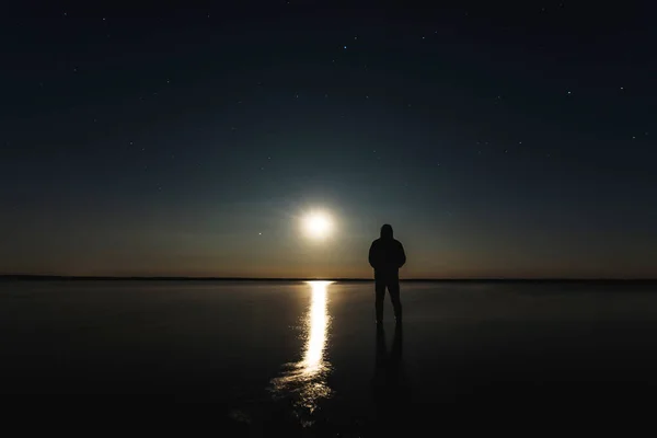 Hombre Encuentra Puesta Sol Luna Bajo Cielo Estrellado Con Estrellas —  Fotos de Stock