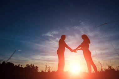 Güzel bir gün batımı karşı el ele tutuşarak mutlu genç bir çift. Özgürlük, mutluluk, zevk kavramı. Umut, özgürlük sembolü. Bir aile.