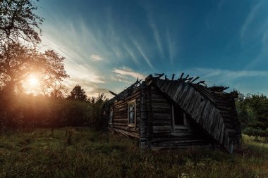Yaratıcı arka plan, terk edilmiş ahşap bir evde, bir kulübe karşı güzel bir gün batımı. Bir büyülü arka plan, fantezi, Tasavvuf, yıkım, yaşlılık kavramı.