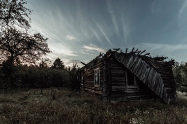 Yaratıcı arka plan, terk edilmiş ahşap bir evde, bir kulübe karşı güzel bir gün batımı. Bir büyülü arka plan, fantezi, Tasavvuf, yıkım, yaşlılık kavramı.