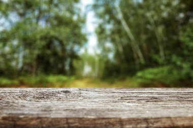 Bakan bir bulanık yeşil bokeh arka plan, metniniz için kopya alanı boş bir ahşap masa. Yaratıcı arka plan, yükleme için bir yer. Doğa kavramı