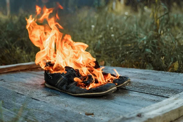 Kreativer Hintergrund Brennende Schuhe Auf Einem Hölzernen Hintergrund Das Konzept — Stockfoto