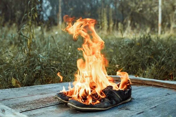 Kreativer Hintergrund Brennende Schuhe Auf Einem Hölzernen Hintergrund Das Konzept — Stockfoto