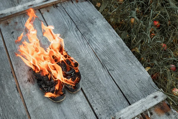 Kreativer Hintergrund Brennende Schuhe Auf Einem Hölzernen Hintergrund Das Konzept — Stockfoto