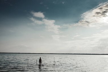 Gölde sabah duran bir çocuk. Çocuk içinde belgili tanımlık karanlık su içine alır. Yaratıcı arka plan, Tasavvuf, yalnızlık, unutkanlık kavramı.