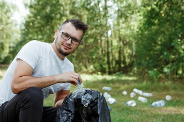 Gönüllü olarak, gönüllü iş. Bir erkek bir çöp torbası tutan gönüllü plastik toplar. Doğa plastik, kirliliği kavramı Temizleme.