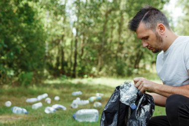 Gönüllü olarak, gönüllü iş. Bir erkek bir çöp torbası tutan gönüllü plastik toplar. Doğa plastik, kirliliği kavramı Temizleme.