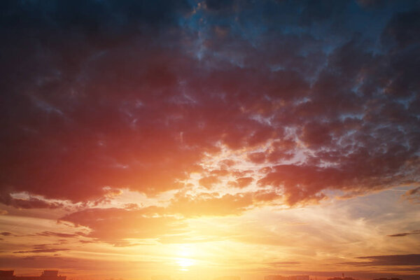 Creative background. Beautiful, atmospheric sunset in the sky. Red, yellow rays of the setting sun.